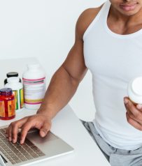Hombre investigando suplementos deportivos en su portátil