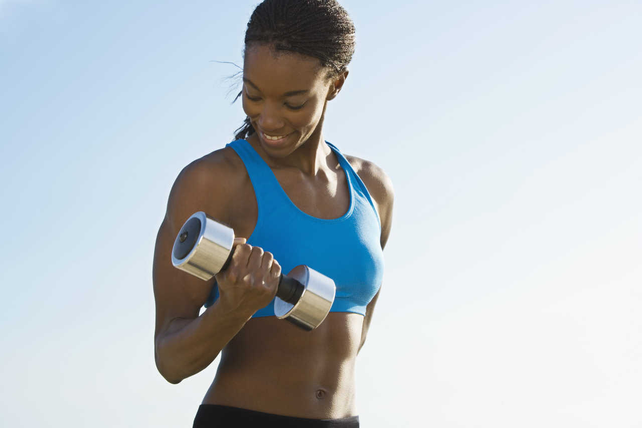 Mujer entrenando con mancuerna en rutina fitness en Sant Celoni